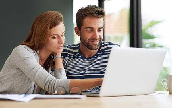 Paar sucht am Laptop nach einer Allianz Direct Versicherung